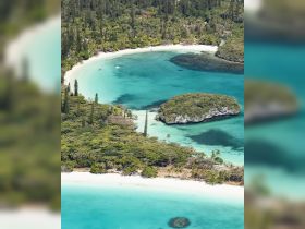 A stunning aerial view of a secluded bay with turquoise waters and lush greenery, perfect for exploring hidden beaches and enjoying nature's beauty.