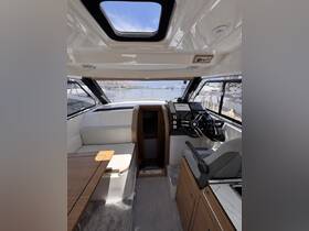 A sleek interior view of a boat's helm and cabin area, showcasing modern seating and navigation equipment, perfect for comfortable cruising.