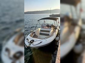 A sleek speedboat docked in calm waters, showcasing its modern design and inviting seating area, perfect for leisurely outings on the water.