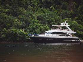 A sleek yacht glides through calm waters, showcasing its elegant design against a lush green backdrop — perfect for luxury cruising.