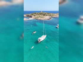 A vibrant scene of guests enjoying the turquoise waters while sailing near a picturesque island — perfect for summer adventures and water activities.