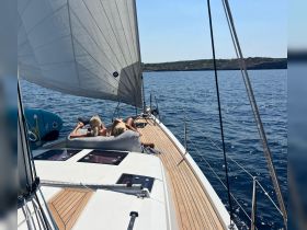 A couple enjoys a relaxing moment on the deck of a yacht while sailing through calm waters, perfect for a serene getaway.