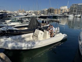 A family enjoys a sunny day aboard a boat in the marina, capturing the essence of fun and relaxation on the water.