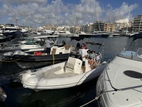 A group of friends poses on their boat at the marina, ready for a day of adventure on the water.