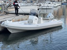 A sleek speedboat docked at the marina, with a crew member preparing for departure. Ideal for quick trips and water adventures.