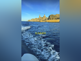 A picturesque view of a coastline with historic architecture, capturing the essence of summer on the water — perfect for exploring vibrant destinations.