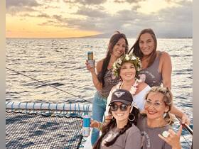 A joyful group of friends celebrates at sunset aboard a boat, enjoying drinks and each other's company — perfect for memorable gatherings and celebrations on the water.