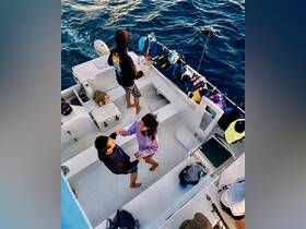 A couple shares a joyful moment aboard a boat, surrounded by friends and vibrant gear — perfect for a fun day on the water.