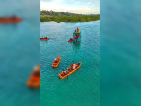 A vibrant scene of kayakers exploring turquoise waters, with a group enjoying a boat ride in the background — perfect for adventure seekers and nature lovers.