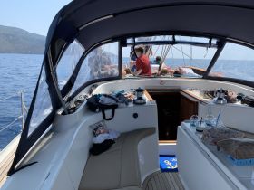 Inside view of a sailboat's cabin with guests relaxing and enjoying drinks — a perfect setting for a day on the water.