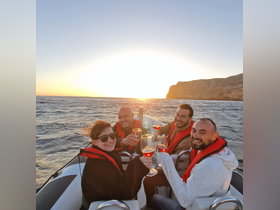 A cheerful group toasts with cocktails on a boat at sunset, creating a perfect atmosphere for celebrations and memorable moments on the water.