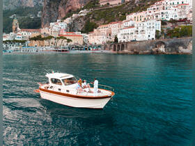 A lively group enjoys a scenic boat ride along the Amalfi Coast, surrounded by stunning coastal views and charming architecture.