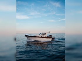 A group enjoys a scenic ride on a boat, gliding through calm waters under a beautiful sky — perfect for memorable outings and adventures on the sea.
