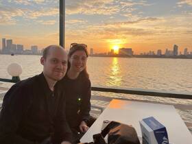 A couple enjoys a romantic sunset on a boat, capturing the perfect moment against a stunning skyline backdrop — ideal for memorable evening cruises.