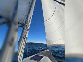 A stunning view of a sailboat's sails against a clear blue sky, showcasing the beauty of sailing on open waters.