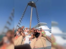 A lively group enjoys a sunny day on a boat, relaxing and sharing snacks — perfect for a fun-filled outing on the water.