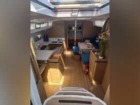 A spacious and well-lit interior of a yacht featuring a dining area and seating, perfect for relaxing and enjoying meals while on the water.