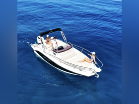 A couple enjoys a sunny day on a boat, with one person steering while the other relaxes in the sun — a perfect scene for summer adventures on the water.