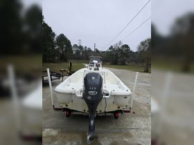A clear view of a center console boat from the back, showcasing its motor and structure, ideal for fishing or leisure activities.