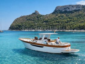 A scenic view of a boat cruising through crystal-clear waters, with a backdrop of lush hills and a marina, perfect for showcasing coastal adventures.