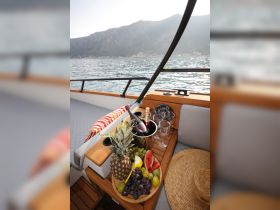 A beautifully arranged platter of fresh fruits and champagne on a boat, perfect for a luxurious day on the water. Ideal for catering and onboard celebrations.
