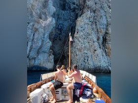 A group of friends enjoys a sunny day on a boat, capturing the stunning rock formations in the background — perfect for memorable adventures on the water.