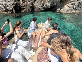 A lively group enjoys a sunny day on a boat, capturing memories against the backdrop of crystal-clear waters — perfect for summer adventures and snorkeling trips.