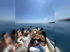 A lively group enjoys a fun day on the water, capturing memories aboard a boat under the bright sun — perfect for summer outings and celebrations.