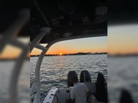 A couple enjoys a romantic sunset view from their boat, creating the perfect atmosphere for an evening on the water.