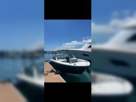 A sleek speedboat docked at a marina under a clear blue sky, showcasing its modern design and inviting atmosphere for a day on the water.