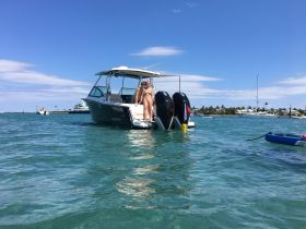 Two friends enjoy a sunny day on a boat, showcasing a perfect moment of fun and relaxation on the water.