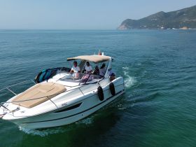 A speedboat glides through calm waters with passengers enjoying the ride — perfect for exploring coastal destinations.