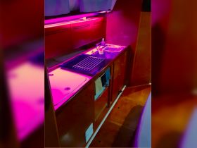 A well-lit view of the boat's kitchen area, showcasing modern amenities and a sleek design, perfect for onboard dining experiences.