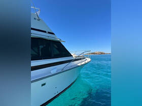 A stunning side view of a yacht gliding through crystal-clear turquoise waters, showcasing its sleek design against a bright blue sky.
