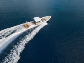 A stunning aerial view of a sleek speedboat cruising through deep blue waters, perfect for thrilling adventures on the open sea.