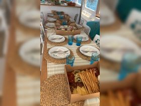 A beautifully arranged dining setup on a boat featuring a selection of charcuterie and refreshments, perfect for onboard gatherings and meals.