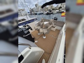 A well-appointed interior view of a boat's helm and seating area, showcasing comfortable chairs and a sleek design, perfect for a day on the water.