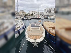 A sleek speedboat named 'ACTIV' docked at a marina, showcasing its stylish design and wooden deck — perfect for day trips on the water.