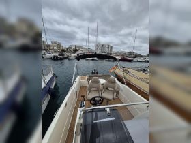 An inviting interior view of a boat showcasing comfortable seating and a helm, perfect for a day on the water.