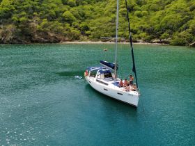 A lively group enjoys a sailing adventure on a beautiful boat, surrounded by stunning coastal scenery — perfect for memorable outings on the water.