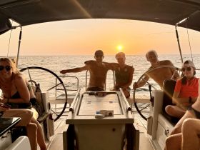 A joyful group enjoys a sunset aboard a yacht, capturing the essence of a perfect evening on the water.