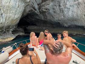 A joyful group of family members enjoys a boat ride exploring a stunning cave, creating unforgettable memories on the water.