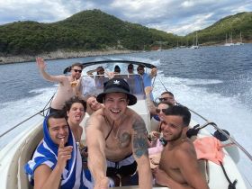 A lively group of friends enjoys a fun day on the boat, capturing memories with smiles and laughter against a beautiful backdrop of nature.