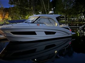 A sleek yacht docked at night, beautifully illuminated and reflecting in the calm waters — perfect for evening cruises or luxury getaways.