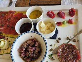 A beautifully arranged charcuterie platter featuring a variety of meats, cheeses, and condiments, perfect for onboard dining experiences.