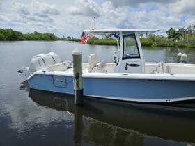 A sleek center console boat docked in calm waters, showcasing its modern design and features, perfect for fishing or leisure outings.