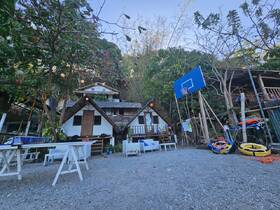 A scenic view of a rustic structure surrounded by greenery, featuring a basketball hoop and various outdoor amenities, ideal for relaxation and recreation.