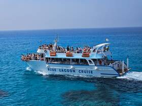 A lively cruise aboard the Blue Lagoon, with guests enjoying the sun and sea on a vibrant boat, perfect for unforgettable ocean adventures.