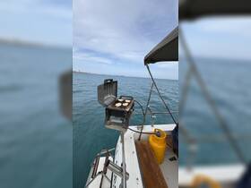 A portable grill is set up on a boat, cooking delicious food while enjoying the serene waters — perfect for onboard dining experiences.