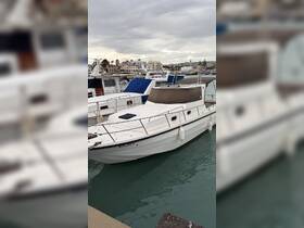 A well-maintained boat named 'Enjoy' docked at the marina, showcasing its sleek design against a backdrop of cloudy skies.